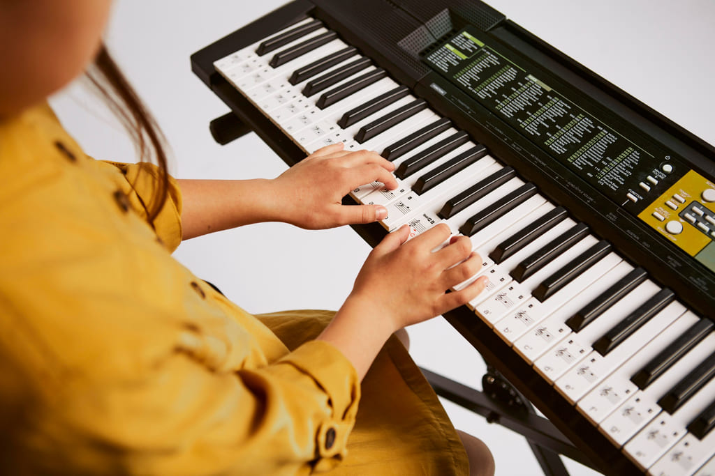 niña tocando un teclado digital